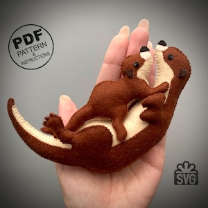 May include: A felt craft pattern for making a brown and cream otter with a smaller otter baby on its back. The pattern includes instructions and an SVG file.