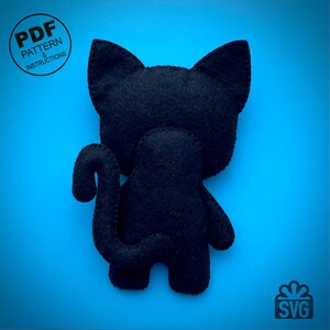 May include: A black felt cat plushie with a curved tail, standing on a blue background. The cat has large, pointed ears and a small body. Text on the image reads "PDF PATTERN & INSTRUCTIONS" and "SVG".