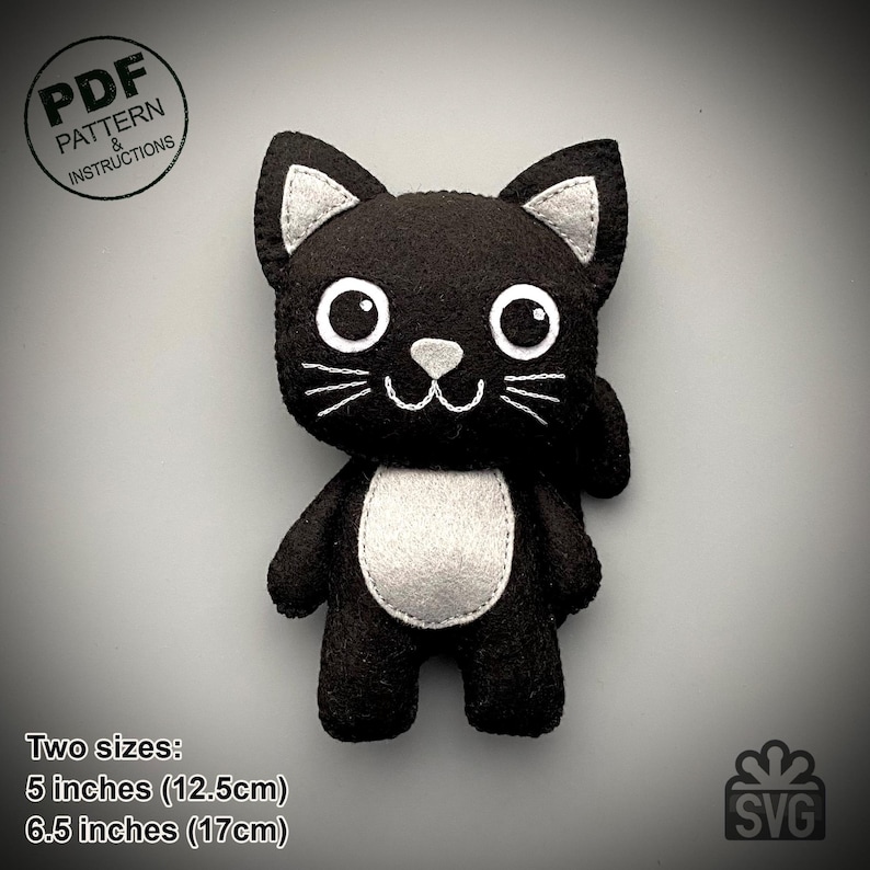 May include: A black felt cat plushie with white accents on the ears, chest, and face. The cat has large white eyes and embroidered whiskers. The plushie is available in two sizes: 5 inches (12.5cm) and 6.5 inches (17cm). The image includes the text "PDF PATTERN & INSTRUCTIONS".