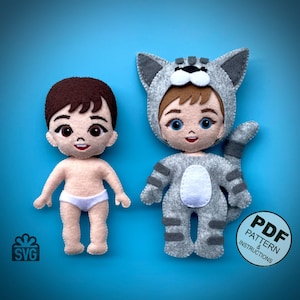 Puede incluir: Un patrón de artesanía de fieltro para dos muñecas de niño, una con un disfraz de gato gris con vientre blanco y la otra con un pañal blanco. El patrón incluye instrucciones en PDF y archivos SVG.