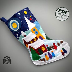 Peut inclure: Une chaussette de Noël en feutre avec une scène hivernale fantaisiste. Le motif présente un ciel nocturne bleu foncé avec des étoiles, une église et des personnages marchant dans la neige. La chaussette a une boucle pour l'accrocher et le texte "PDF PATTERN & INSTRUCTIONS".