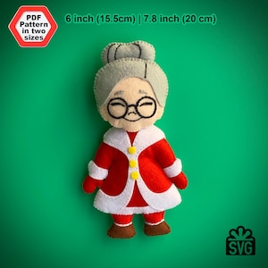 May include: A felt Christmas ornament pattern of a grandmother wearing a red and white Santa suit with a white fur trim. The pattern is available in two sizes: 6 inches (15.5 cm) and 7.8 inches (20 cm).