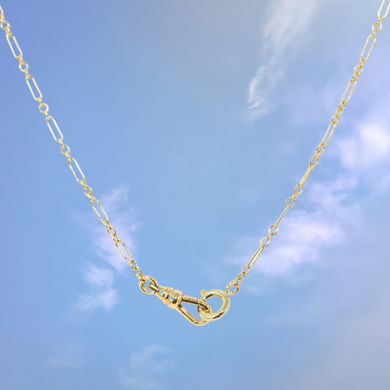 Quinney Collection's handcrafted gold filled Albert necklace, features a classic trombone link and a distinctive vintage style dog clip clasp. This piece is a modern homage to the timeless pocket watch chain, offering both style and practicality.