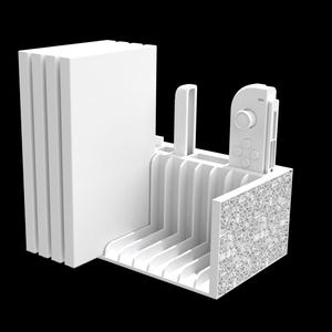 Puede incluir: Soporte de plástico blanco para una consola Nintendo Switch y sus mandos. El soporte tiene ranuras para cartuchos de juegos y un lugar para guardar la consola en posición vertical. El soporte también tiene un lugar para guardar dos mandos Joy-Con.