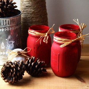 Red distressed mason pint jar trio, Christmas decor, tied with raffia bows.