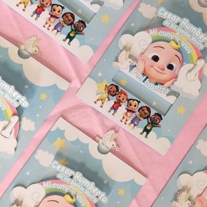 May include: A blue and white invitation card with a rainbow and a cartoon baby character. The text on the card reads "Cesar Humberto de los Santos Rivera Mi cumpleanos y mi bautizo".
