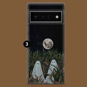 May include: A black phone case with a spooky design featuring two ghosts in a field of tall grass under a full moon and a starry night sky.