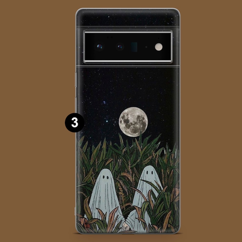 May include: A black phone case with a spooky design featuring two ghosts in a field of tall grass under a full moon and a starry night sky.