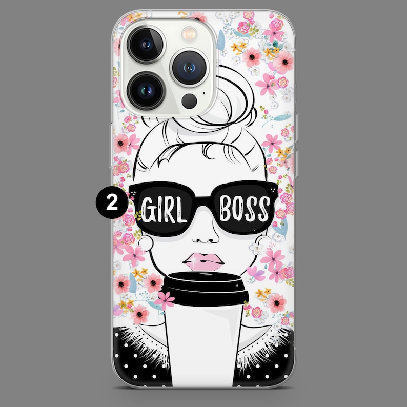 May include: A clear phone case with a floral pattern and a black and white illustration of a woman wearing sunglasses and holding a coffee cup. The text "GIRL BOSS" is printed on the sunglasses.
