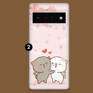 Puede incluir: Una funda de tel&eacute;fono rosa con un dise&ntilde;o de dos gatos de dibujos animados abraz&aacute;ndose. Los gatos son blancos y grises con detalles rosas. El fondo es un patr&oacute;n floral rosa y blanco.