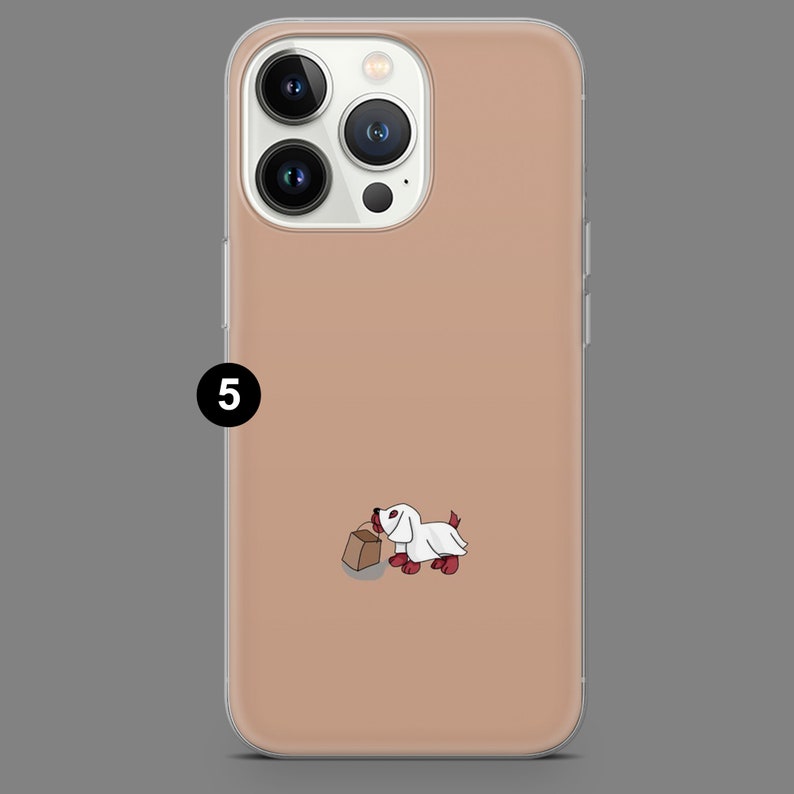 Puede incluir: Una funda de tel&eacute;fono transparente con un fondo de color melocot&oacute;n. Una ilustraci&oacute;n de dibujos animados de un perro con un disfraz de fantasma blanco y sosteniendo una bolsa de papel marr&oacute;n est&aacute; en la funda.