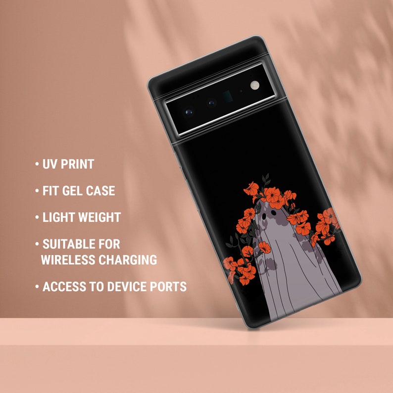 May include: A black phone case with a ghost design and red flowers. The case is made of gel and has a UV print. It is suitable for wireless charging and has access to device ports.