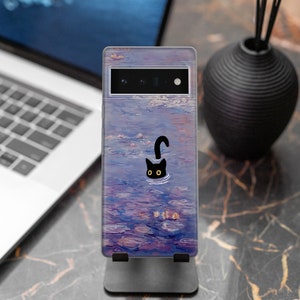 May include: A phone case with a black cat silhouette swimming in a purple and blue water lily pond. The case has a clear back and a black camera cutout.