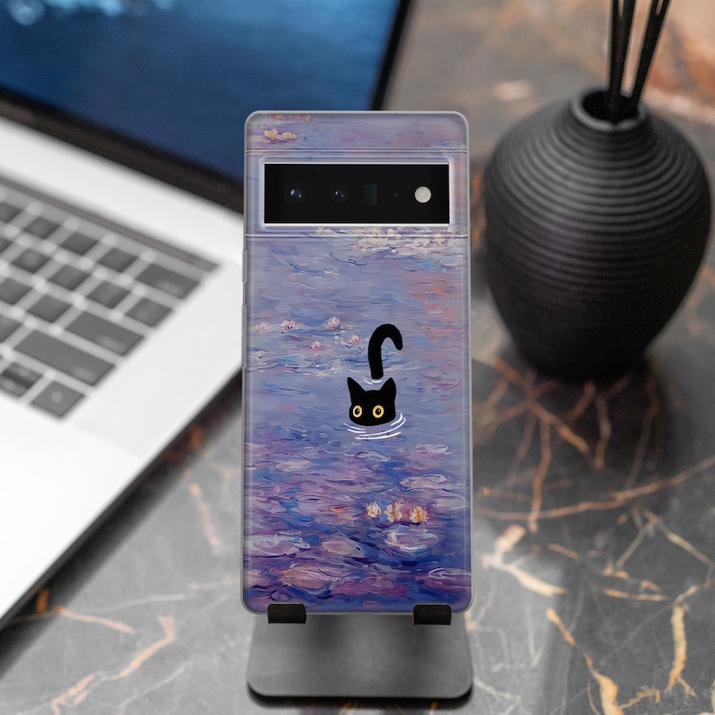 May include: A phone case with a black cat silhouette swimming in a purple and blue water lily pond. The case has a clear back and a black camera cutout.