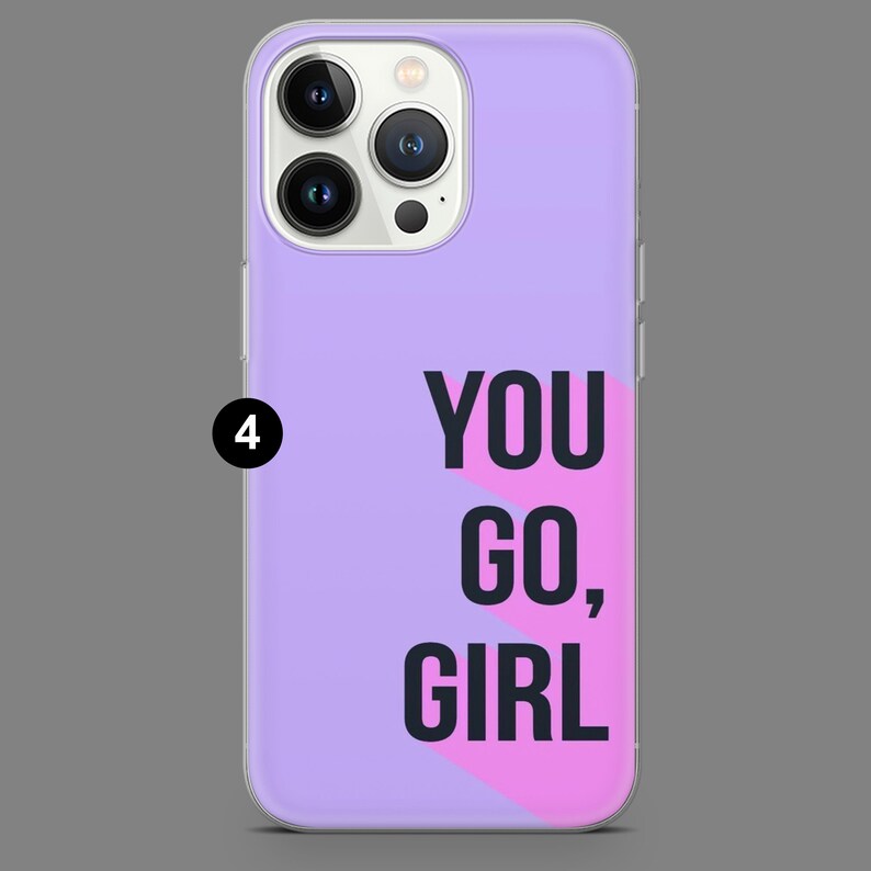May include: A purple phone case with a pink and white geometric design. The text "YOU GO, GIRL" is printed in black on the case.