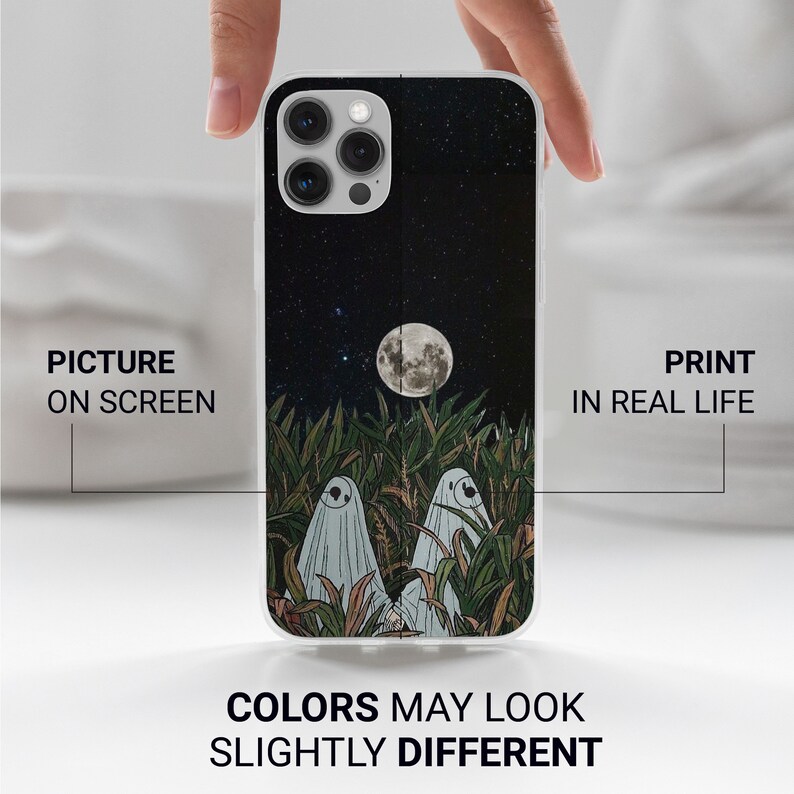 Puede incluir: Carcasa blanca para iPhone con una ilustraci&oacute;n en blanco y negro de dos fantasmas en un campo de hierba alta bajo una luna llena y un cielo estrellado.  "Picture on screen" y "Print in real life" est&aacute;n escritos en los lados izquierdo y derecho de la imagen.