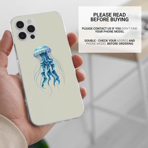 May include: A clear phone case with a blue jellyfish illustration. The case is designed for a phone with a triple camera lens.