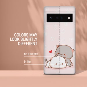 Puede incluir: Una funda de tel&eacute;fono rosa con una linda ilustraci&oacute;n de dibujos animados de dos gatos. La funda tiene un borde blanco y un recorte para la c&aacute;mara. Los gatos son grises y blancos y se abrazan. El fondo es rosa con lunares blancos y otras peque&ntilde;as ilustraciones.