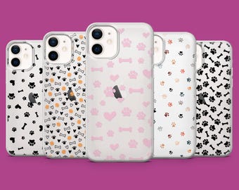 May include: Five clear phone cases with different paw print designs. The cases are all for the iPhone 13 Pro Max. The designs include black paw prints, orange paw prints, pink paw prints, and a combination of pink paw prints, hearts, and bones.
