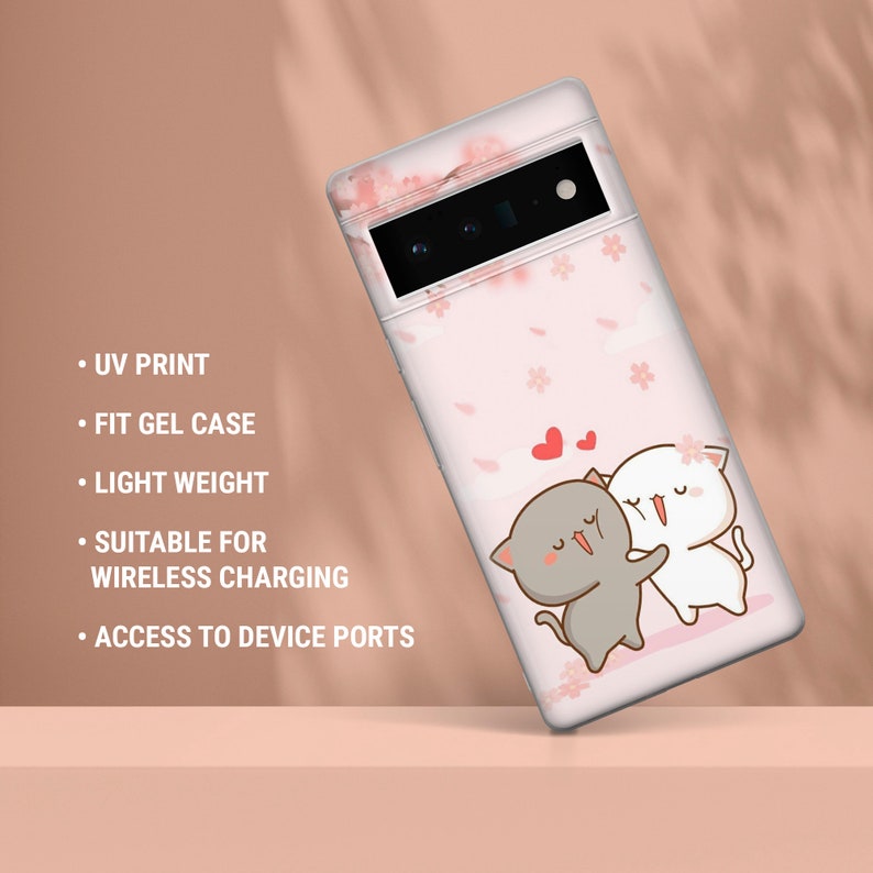 Puede incluir: Una funda de tel&eacute;fono rosa con un dise&ntilde;o de dos gatos de dibujos animados abraz&aacute;ndose. La funda tiene una parte posterior transparente y un patr&oacute;n floral rosa. La funda es compatible con la carga inal&aacute;mbrica.