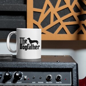 May include: A set of three ceramic mugs with a speckled, matte finish. The mugs are in shades of cream, light brown, and dark brown. Each mug has a simple, minimalist design and a rounded handle.