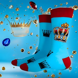 May include: A pair of blue socks with a red cuff. The socks feature a black crown and a gold crown with blue and red accents. The socks are surrounded by gold and blue jewels.