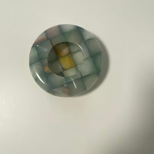 以下が含まれることがあります： チェック柄の緑、白、黄色の丸い大理石のアッシュトレイ