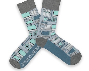 Peut inclure: Une paire de chaussettes bleues et grises avec un motif d'icônes informatiques et le texte "KEYBOARD WARRIOR".