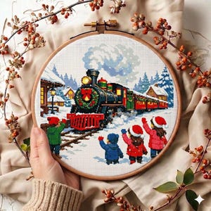 May include: A cross-stitch embroidery hoop featuring a winter scene with a train, snow, and children waving. The train is decorated with a wreath and has red, green, and black details. The children are wearing red and blue coats and hats.