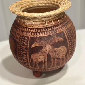 Hermosa calabaza africana antigua tallada a mano en madera marrón.
