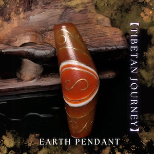 Puede incluir: Un colgante de Tierra marrón y naranja con diseños de remolinos dorados y detalles en blanco. El colgante tiene el texto "Tibetan Journey" y "Earth Pendant" en la imagen.