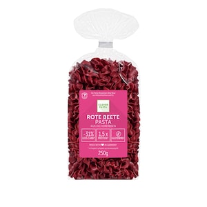 May include: A transparent bag containing red pasta. The bag features a pink label with the words "ROTE BEETE PASTA" and "AUS KICHERERBSEN". The label also states the pasta is gluten-free and weighs 250g.