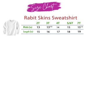 Puede incluir: Una sudadera blanca Rabit Skins se muestra con una tabla de tallas. La tabla, con el texto "Size Chart" arriba, enumera las tallas 2T a 7T, con medidas de ancho y largo en pulgadas. La sudadera es lisa.