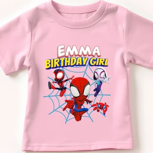 Puede incluir: Camiseta rosa con tem&aacute;tica de Spider-Man. Presenta un gr&aacute;fico de Spider-Man, Spider-Gwen y otro personaje de Spider-Man. El texto "Emma Birthday Girl" est&aacute; impreso en la camiseta.