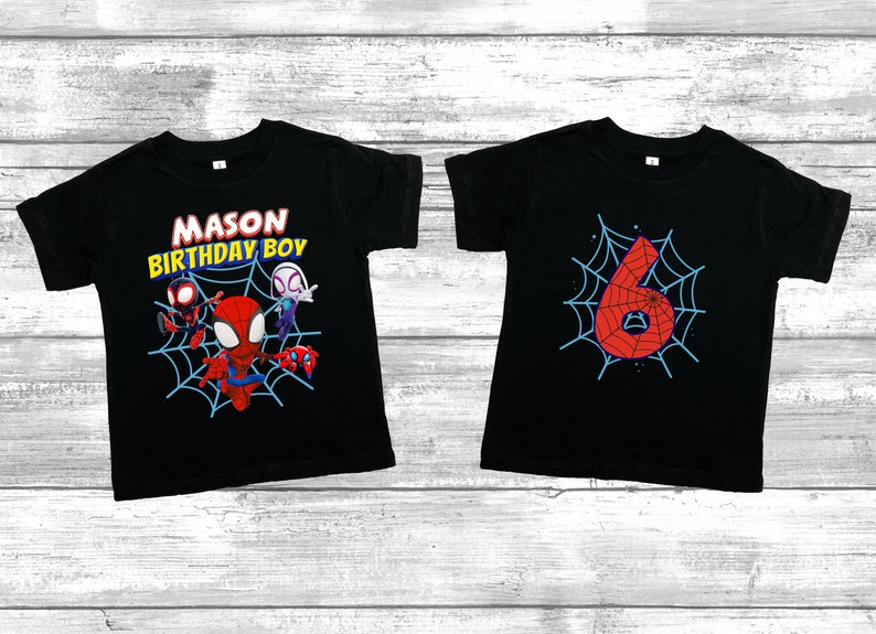 Puede incluir: Dos camisetas negras con tem&aacute;tica de Spiderman. Una camiseta tiene un gr&aacute;fico de Spiderman y otros personajes con el texto "MASON BIRTHDAY BOY". La otra camiseta tiene un gr&aacute;fico de un n&uacute;mero 6 rojo en una telara&ntilde;a azul.