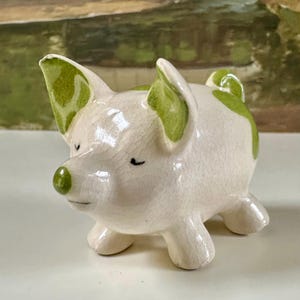 May include: A set of three ceramic mugs with a speckled, matte finish. The mugs are in shades of cream, light gray, and dark gray. Each mug has a simple, minimalist design, perfect for coffee or tea.