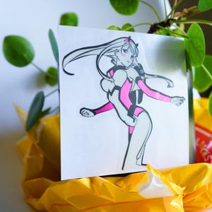 May include: A white sticker with a black and pink illustration of a female anime character with long hair. The character is wearing a pink and white outfit and is posed in a dynamic action pose.