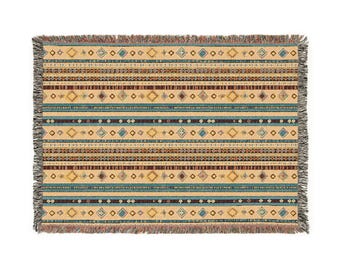 May include: A woven throw blanket with a geometric pattern in shades of brown, blue, and yellow. The blanket has a fringed edge.