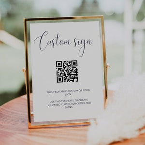 May include: A gold-framed sign with the text "Custom sign" and a black and white QR code. The text below the QR code reads "Fully editable custom QR code sign. Use this template to create unlimited custom QR codes and signs."