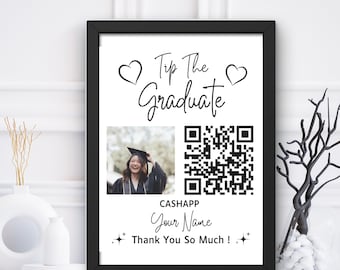 May include: Black and white printable sign with the text "Tip the Graduate" and two hearts. The sign also includes a QR code and a photo of a person wearing a graduation cap and gown. The text "CashApp Your Name Thank You So Much!" is also included.