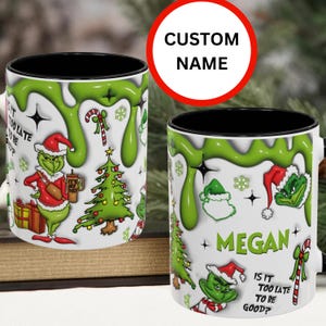 May include: A white ceramic mug with a black rim and handle. The mug features a green Grinch character, a Christmas tree, candy canes, and snowflakes. The text "Is it too late to be good?" is printed on the mug. The mug is personalized with the name "Megan".