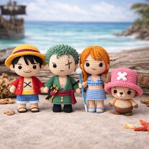Puede incluir: Cuatro muñecos de ganchillo de personajes de la serie de anime One Piece. Los muñecos están de pie en una playa de arena con un barco al fondo. Los muñecos incluyen a Luffy, Zoro, Nami y Chopper, cada uno con atuendos y accesorios distintos.