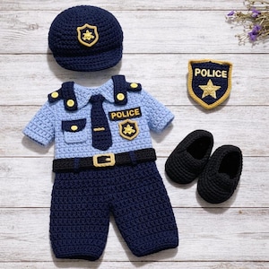 May include: A handmade crochet police officer costume set in navy blue and light blue. The set includes a hat, shirt, pants, badge, and shoes. The shirt has a tie, belt, and the word "POLICE" on it. The badge has a gold star.