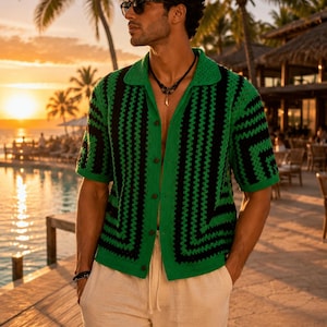 May include: A green and black crochet shirt with a collared neckline and short sleeves. The shirt has a button-down front and a geometric pattern. The person is wearing sunglasses and beige pants.