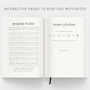 May include: A black and white journal with the text "Interactive Pages to Keep You Motivated" on the cover. The left page features a progress tracker with 100 numbered circles. The right page has the title "Chapter Reflections" with the word "Love" underneath. There are five emoji icons and space for writing.