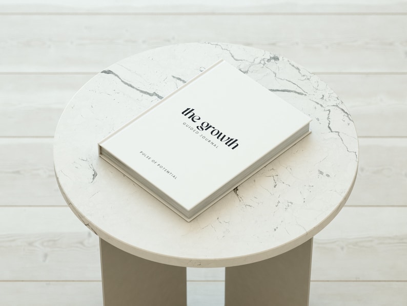 May include: A white journal with the text "the growth guide to journal" and "pulse of potential" on the cover.