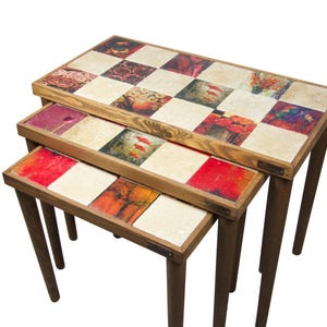 Peut inclure: Un ensemble de trois tables gigognes avec un motif en damier de carreaux colorés. Les carreaux présentent une variété de motifs floraux et abstraits. Les tables sont en bois et ont une finition rustique.