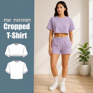 May include: A woman wearing a lavender cropped t-shirt and matching shorts. The outfit is paired with white sneakers and socks. The image also features a PDF pattern for a cropped t-shirt.