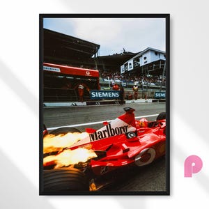 Könnte beinhalten: Gerahmter Druck eines roten Formel-1-Rennwagens mit dem Marlboro-Logo, Flammen aus dem Auspuff. Das Auto befindet sich auf einer Rennstrecke, im Hintergrund ist das Siemens-Logo zu sehen.