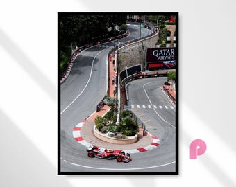 May include: A framed print of a Formula 1 race in Monaco. The image shows a red and white race car on a winding track with a large Qatar Airways sign. The track is surrounded by barriers and spectators.